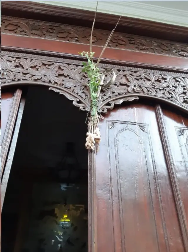 Alang-alang dan opo-opo yang diletakkan di depan pintu