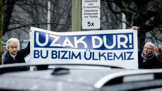 Wilders "Uzak dur, bu bizim ülkemiz" yazılı pankart ile