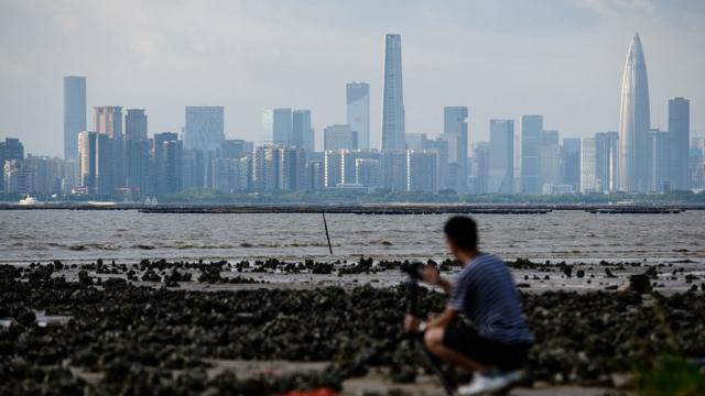 一名男子在香港隔海拍摄深圳天际线。