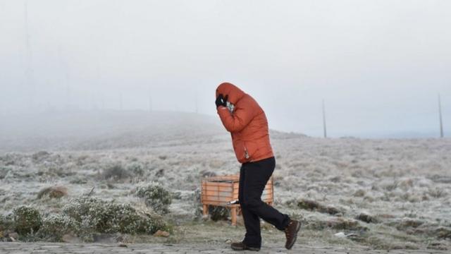 Pessoa caminhando com agasalho e capuzloteca da caixaSanta Catarina