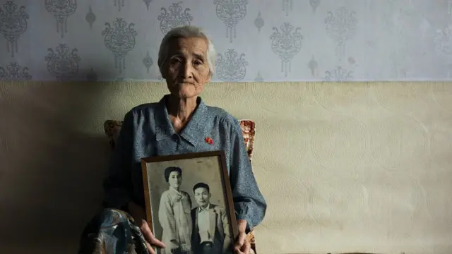 조선인 남편과 함께 찍은 사진을 들고 있는 이데 타키코 씨