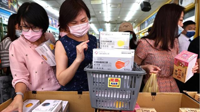 People buy boxes of protective face masks following the outbreak of coronavirus disease (COVID-19), in Taipei, Taiwan, May 12, 2021