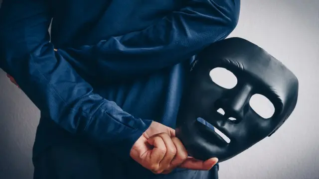 Una persona con una máscara en su mano