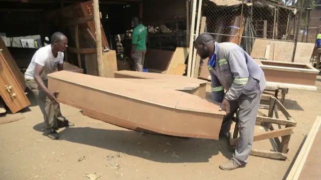 A ranar Juma'a masu kera akwatin gawa a Harare na Zimbabwe na kammala aikin kera wani akwaitin gawa