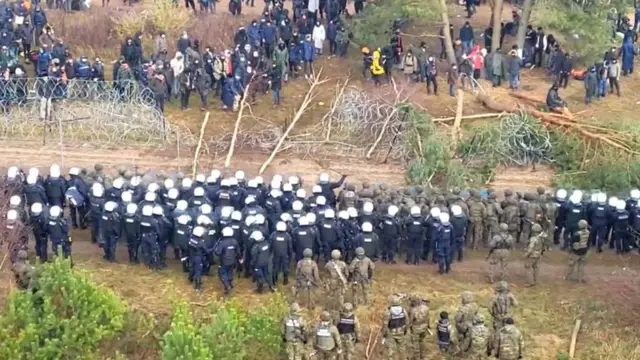 Migrantes y policías en la frontera entre Polonia y Bielorrusia.