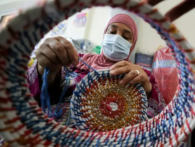 A Masar ranar Litinin, wannan matar tana saka kwando da robobin da ake sake sarrafawa da aka bebo daga Kogin Nilu.