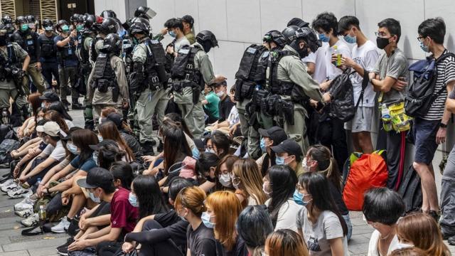 Police officers opening detainees" bags and checking on their smartphones as police has set up a police cordon around the area in Causeway Bay, Hong Kong, China, 27 May 2020. The Second Reading debate on the National Anthem Bill is set to resume at the Legislative Council on 27 May amid growing anger at Beijing"s plan to impose a national security law on the city banning sedition, secession and subversion through a method that could bypass Hong Kong"s legislature.