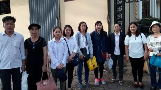 Thân nhân các nhà hoạt động đứng bên ngoài toà trong giờ toà nghỉ trưa