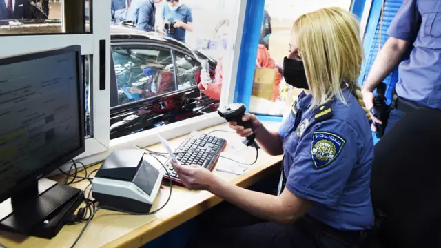 Police officer at the Bregana border crossing between Croatia and Slovenia scans QR code on an EU digital Covid passport