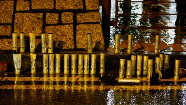 示威者在路旁展示警察发出的催泪烟弹壳。