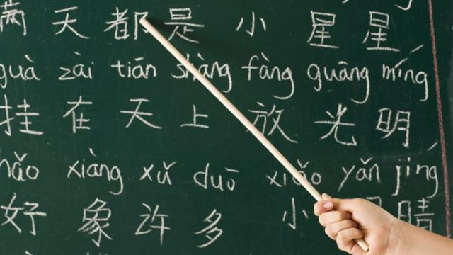 Girl pointing at blackboard in a Chinese lesson