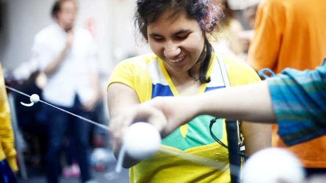 Adolescente tocando esferas que representan los planetas orbitando el Sol