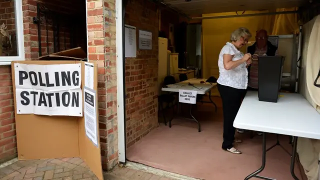 伦敦Croydon一处借用民宅车库的投票站内工作人员准备投票箱（8/6/2017）