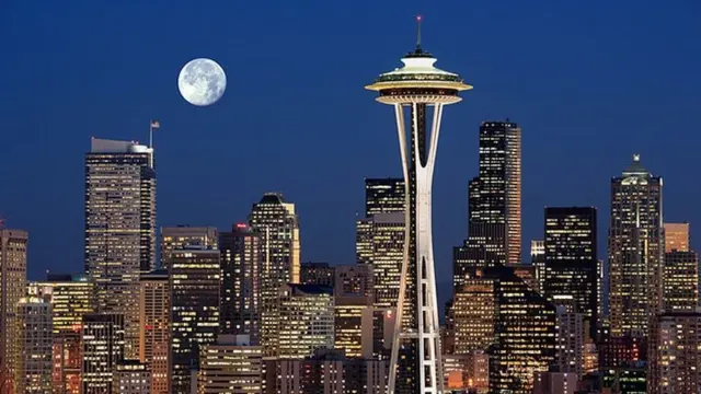 Une image de la Lune au-dessus d'une ville pleine de gratte-ciels.