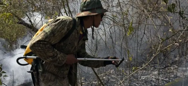 A man trying to put down wildfire in the Amazon