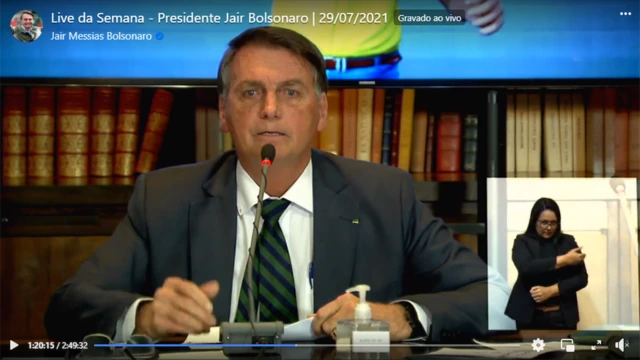 Reproduçãojogo 21 de cartasvídeo no Facebook mostra Bolsonaro, sentado, falando no microfone com livros atrás