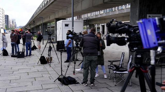 Equipes de TV cobrem uma cena de crime local em Copenhague no verão de 2022