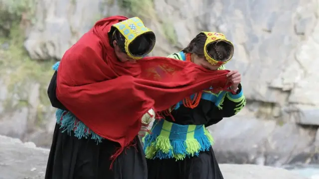 Dve žene pokrivaju lice maramom