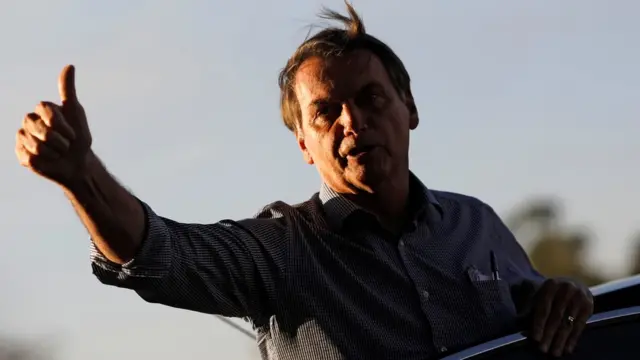 Jair Bolsonaro acenabaixar o jogo de caça níquelárea ao ar livre