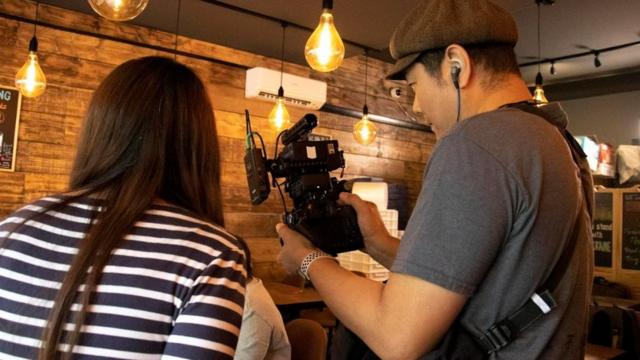 阿军与编导一起在东伦敦一家由港人开设的茶餐厅为“绿豆”的纪录片作拍摄