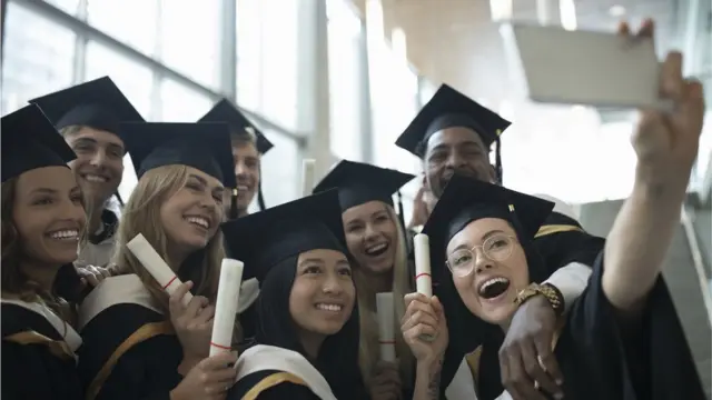 Les étudiants graduant posent pour un selfie