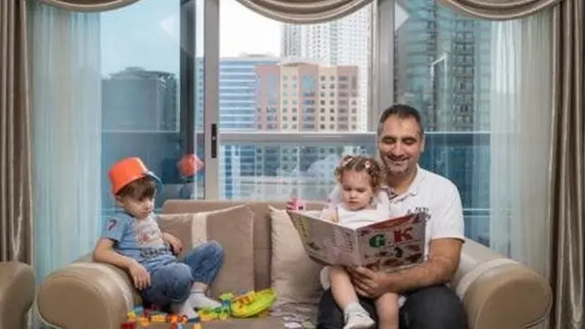 Fuad Kuyali övladları Mazin və Culi üçün Suriyanın Hələb şəhərindən köçüb gəldikləri Dubaydakı evlərində kitab oxuyur