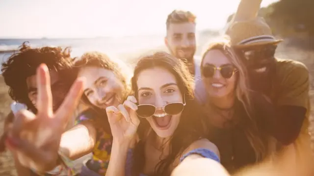 ছুটি কাটাতে গিয়ে সমুদ্রের তীরে সেলফি তুলছেন বন্ধুদের একটি দল