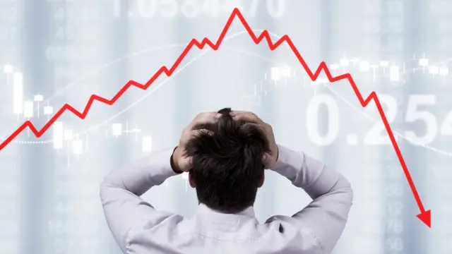 Hombre frente a gráfico mostrando una caída de valores.