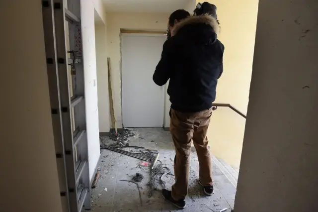 A journalist films debris outside the flat in Montpellier, 10 February