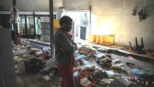 The Ethiopian owner of a looted grocery store in Soweto, Johannesburg, stands in his ransacked shop