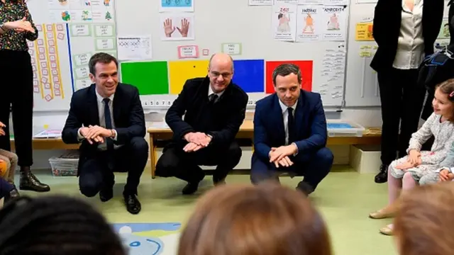 وزیر بهداشت فرانسه (سمت چپ) در کنار وزیر آموزش و جوانان و معاونش با کودکان در مدرسهای حوالی پاریس درباره شستن دستهایشان به منظور جلویگری از ابتلا به ویروس کرونا حرف میزند.