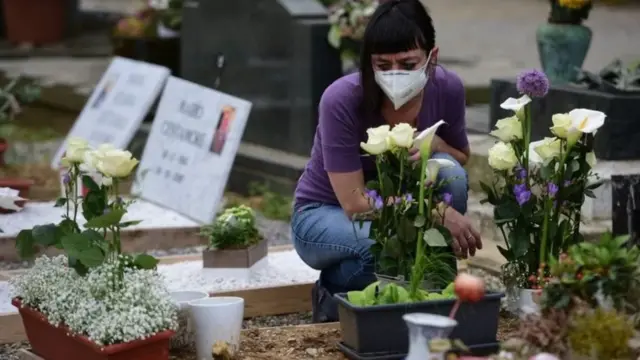 سيدة أمام قبر أحد أقاربها من ضحايا كوفيد-19