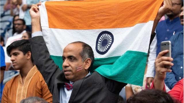去年美国得克萨斯州休斯顿市的印度裔社区为欢迎印度总理莫迪举行了一场名为“你好，莫迪”的集会。图为一名男子高举印度国旗。
