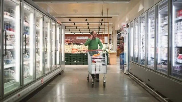 Man with a trolley shopping in a supermarket isle