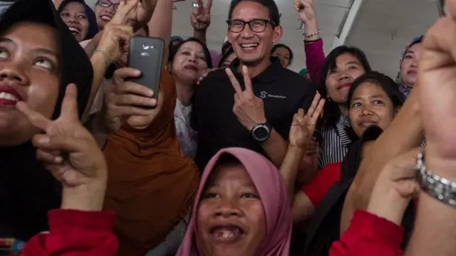 Calon Wakil Presiden pasangan Prabowo Subianto, Sandiaga Uno (tengah) berfoto dengan warga saat kegiatan kunjungan di Pasar Kadipolo, Solo, Jawa Tengah, Sabtu (22/9).