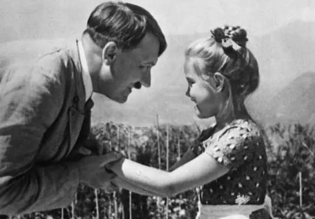 Una niña, que se cree que es Rosa, sostiene las manos de Hitler en una imagen diferente del mismo día.