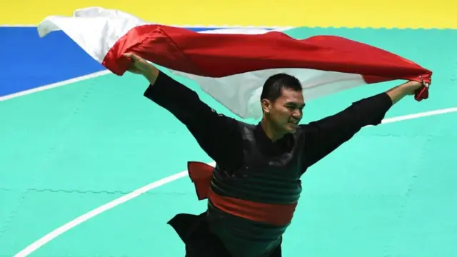 Atlet pencak silat Aji Bangkit Pamungkas menyumbang emas setelah mengalahkan atlet Singapura Sheik Alauddin dengan skor 5-0 di nomor 85 kg