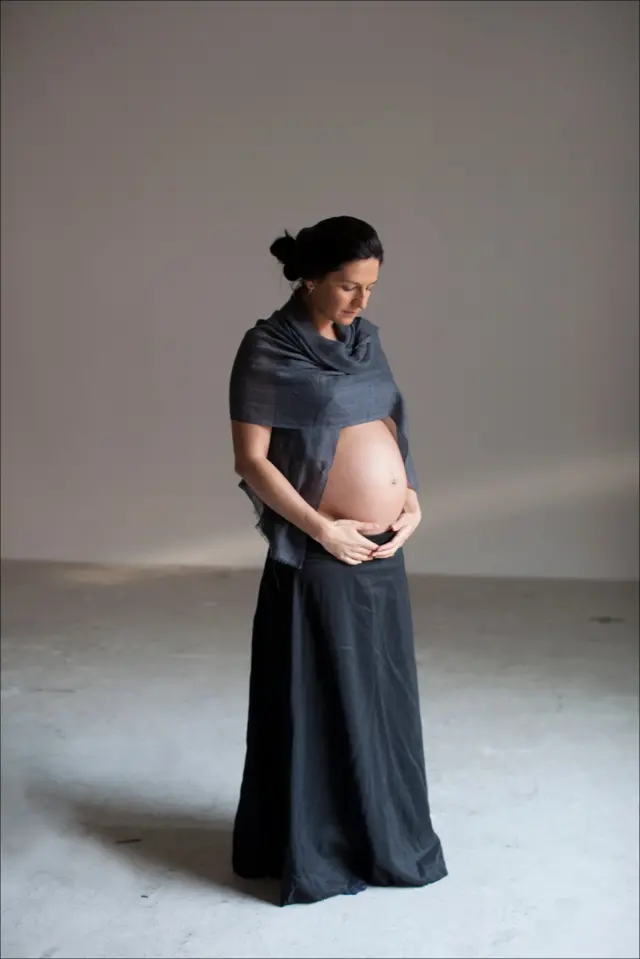 Mujer se agarra su panza en embarazo