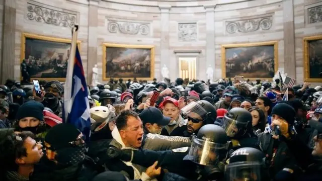 Crowds with flags inside the US Capitol building
