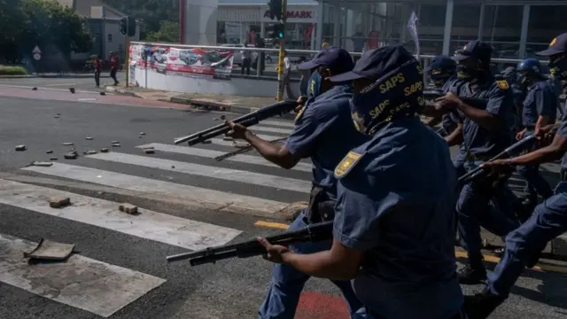 A large group of South African Police Service (SAPS) officers disperse a group of students who were blocking roads during a protest in Braamfontein, Johannesburg, South Africa - Wednesday 10 March 2021