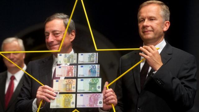 Президент Европейского Центробанка Марио Драги (слева) держит европейскую звезду вместе с президентом Банка Латвии Илмаром Римшевичем (справа) в Латвии в 2013-м году.