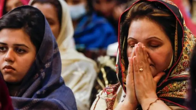 پاکستان میں ایک کرسمس کے موقع پر خاتون کورونا کی وبا کے دوران دعا کر رہی ہیں (فائل فوٹو)