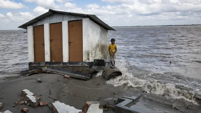 Um menino que perdeu seus pertences com a erosão do rio se refugiabwin bet casinoum abrigo