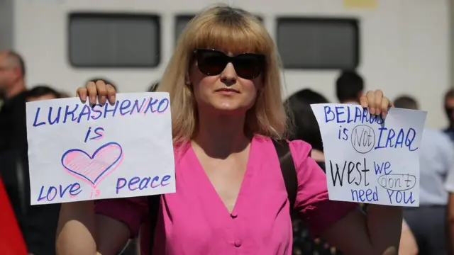 женщина держит самодельные плакаты