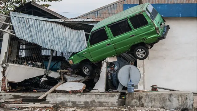 సునామీ కారణంగా అలల ధాటికి కూలిన ఇల్లు, అందులో చిక్కుకున్న కారు
