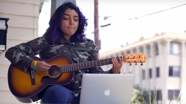 Jovem aprendendo a tocar guitarra