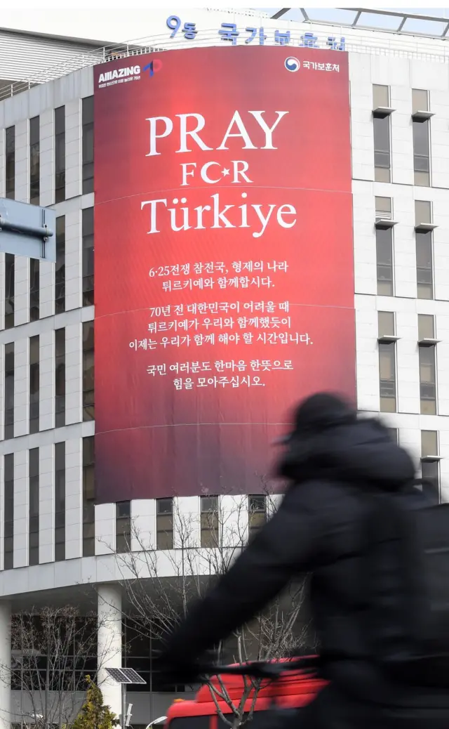13일 오후 세종시 정부세종청사 국가보훈처 외벽에 지진 발생으로 고통 받는 튀르키예 국민들에게 힘을 모아 줄 것을 요청하는 'Pray for Turkiye' 대형 현수막이 붙어 있다
