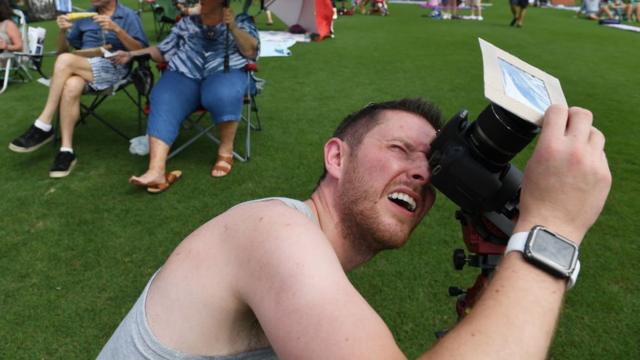 Hombre sacando foto a eclipse solar total.