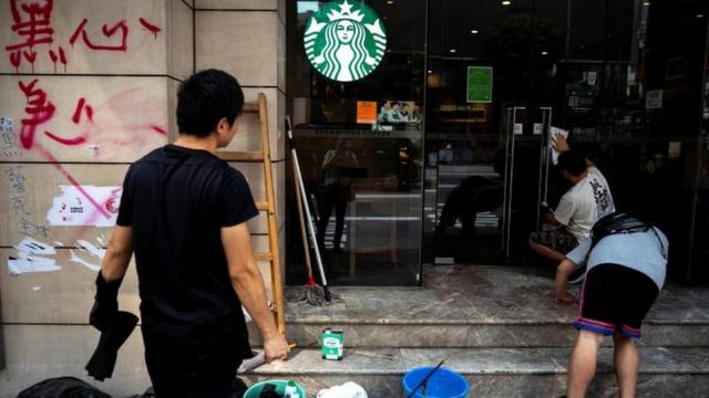 A worker cleans graffiti at a Starbucks coffee shop in Hong Kong on 30 September