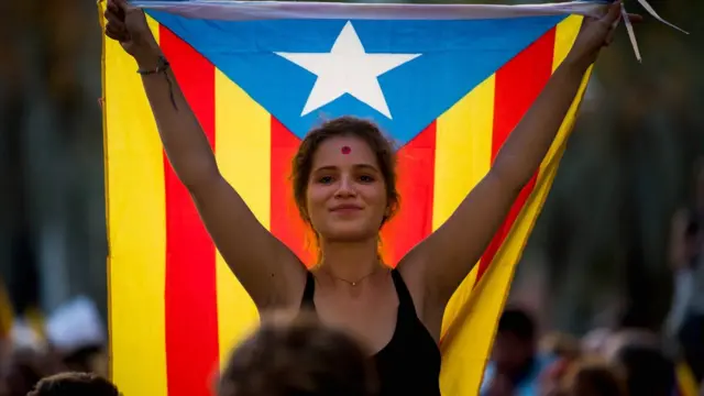 카탈루냐 독립을 지지하는 집회 참가자가 9월 21일 바르셀로나에서 열린 집회에서 카탈루냐 기를 들고 있다